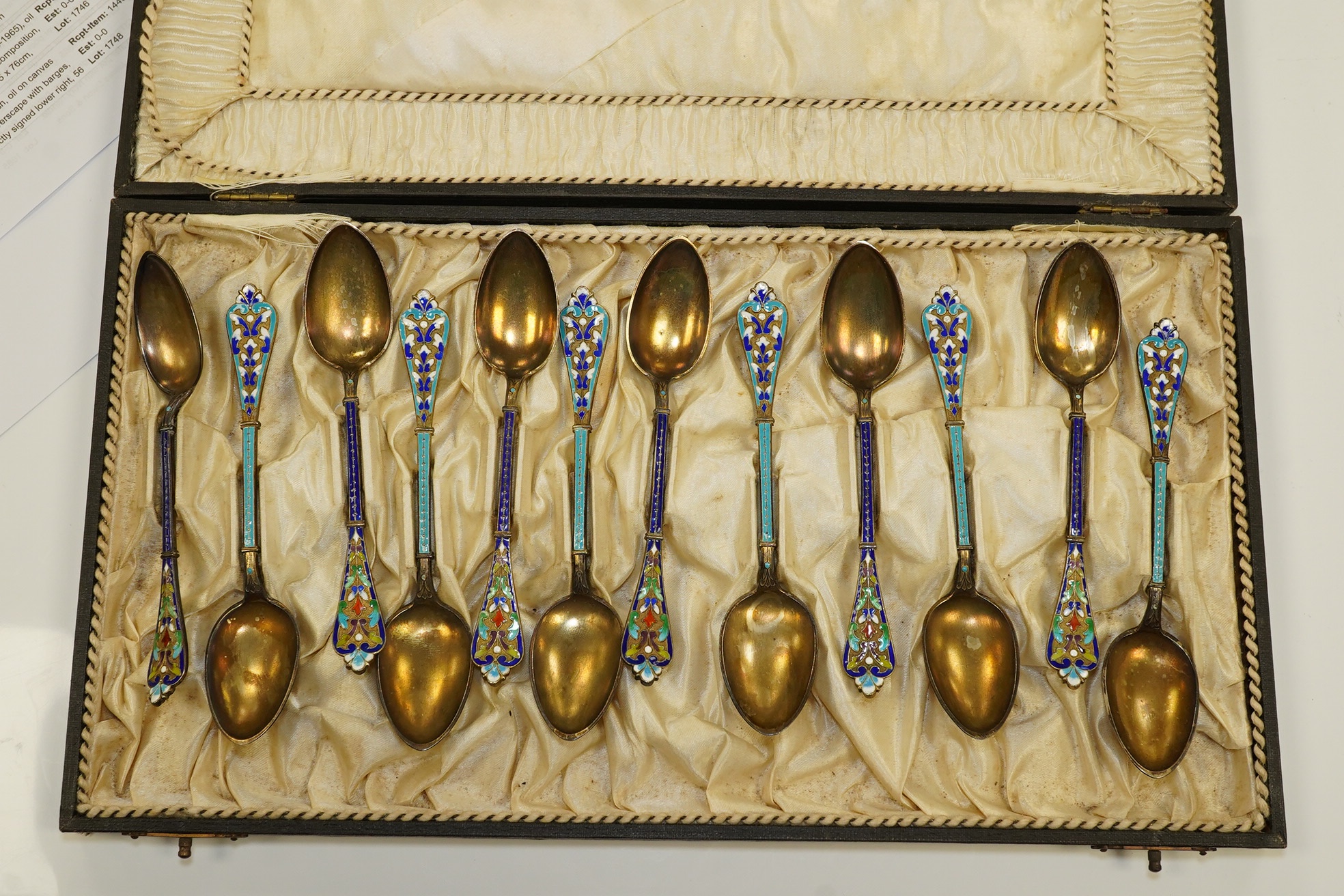 Two sets of Norwegian six enamelled gilt metal and cloisonné enamelled teaspoons, 11.9cm. Condition - poor to fair